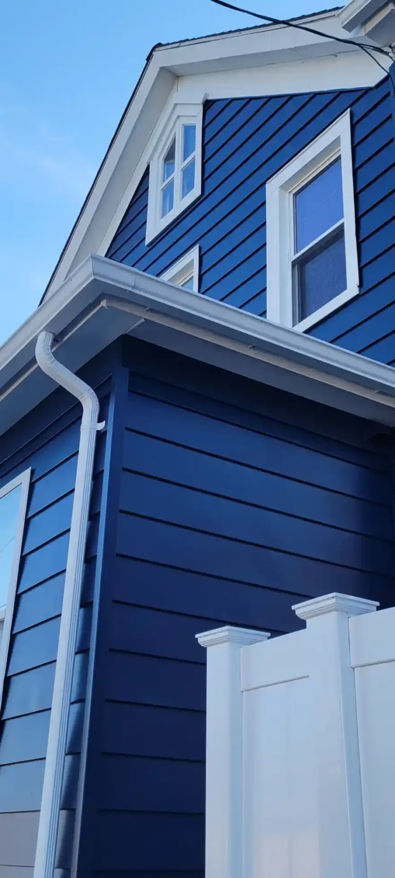 Exterior-House-painting-Dark-blue-aluminum-siding-white-gutters-windows-doors-trim-downspouts-foundation-4